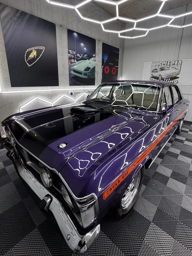 Purple Ford Falcon GT with orange stripes under the hexagon lights